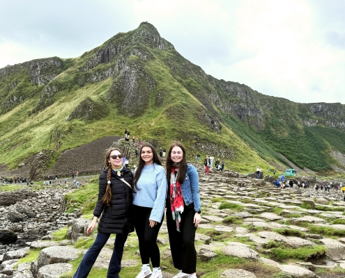 Three girls exploring the Giant’s Causeway in Northern Ireland on an Odyssey Coach Tour